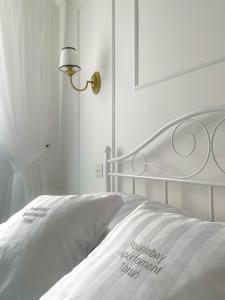a white bed with a white bedspread and a lamp at Podniebny Apartament Toruń in Toruń +61 photos