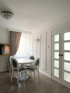 a dining room with a table and chairs and a window at Podniebny Apartament Toruń in Toruń