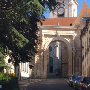 a building with a clock tower with cars parked in front at Domitine in Besançon +10 photos