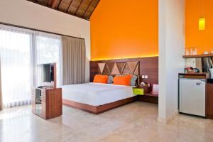 a bedroom with a bed with an orange wall at Villa True Colors in Legian +35 photos