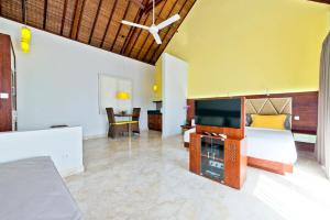 a living room with a couch and a television at Villa True Colors in Legian