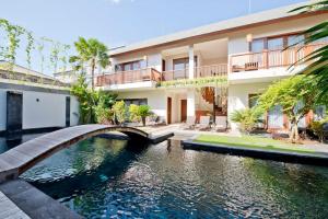 a bridge over a river in front of a building at Villa True Colors in Legian