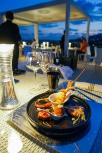 a plate of food on a table with wine glasses at LHP Hotel Montecatini Palace & SPA in Montecatini Terme
