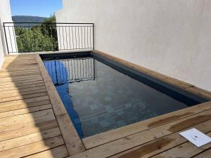 een zwembad met een houten terras en een balkon bij Villa Fautea Verdon in Sainte-Croix-de-Verdon