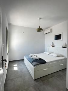 una camera da letto bianca con un letto grande di Psaraki House Serifos a Serifos Chora