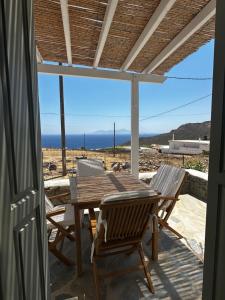un tavolo e sedie su un patio con vista sull'oceano di Psaraki House Serifos a Serifos Chora
