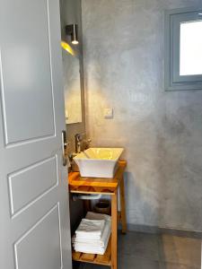 un bagno con lavandino e specchio di Psaraki House Serifos a Serifos Chora