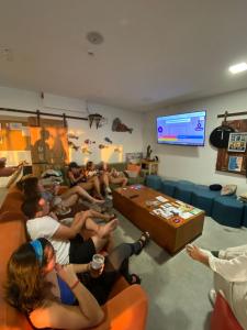 a group of people sitting in a room playing a video game at WOT Ericeira Surf Hostel in Ericeira