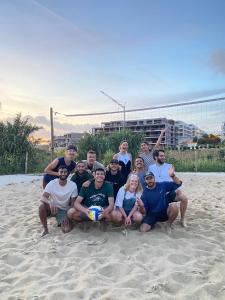 a group of people posing for a picture on the beach at WOT Ericeira Surf Hostel in Ericeira