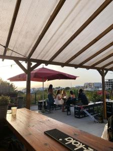 a group of people sitting at a table under an umbrella at WOT Ericeira Surf Hostel in Ericeira