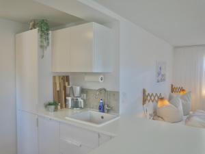 a kitchen with white cabinets and a sink at Moderne Studio Ferienwohnung in Bad Doberan in Bad Doberan +28 photos