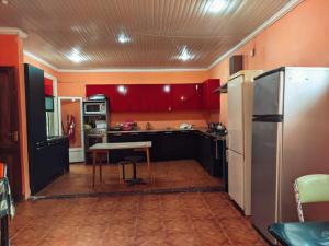 a kitchen with red cabinets and a table and a refrigerator at Hostel Ureki Kidobani in Ureki +23 photos