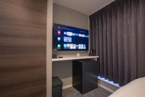 a room with a tv and a bed and a window at inninn HOTEL UENO in Tokyo
