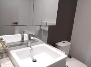 a white bathroom with a sink and a toilet at Docklands Serenity in Melbourne