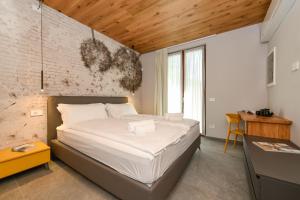 a bedroom with a bed and a brick wall at Villa Beatrice front lake in Rocca dʼAnfo +85 photos