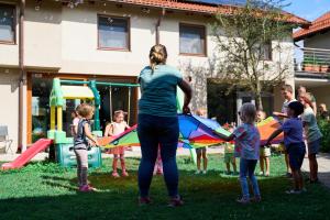a woman holding a kite with a group of children at ATRIUM Apartamenty in Krynica Morska