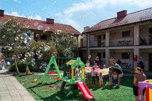 a group of people standing around a playground in a yard at ATRIUM Apartamenty in Krynica Morska
