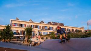 a man riding a skateboard on a ramp in front of a building at WOT Ericeira Surf Hostel in Ericeira