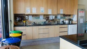 a large kitchen with wooden cabinets and stools in it at WOT Ericeira Surf Hostel in Ericeira
