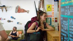 a woman standing at a counter eating food at WOT Ericeira Surf Hostel in Ericeira