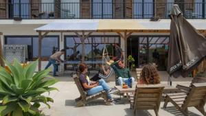 a group of people sitting at a table in a pavilion at WOT Ericeira Surf Hostel in Ericeira