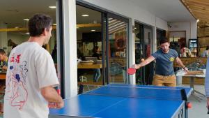 two men playing a game of ping pong at WOT Ericeira Surf Hostel in Ericeira