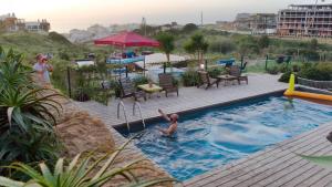 a person in a swimming pool at a resort at WOT Ericeira Surf Hostel in Ericeira