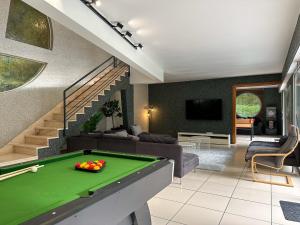 a living room with a pool table at Villa avec piscine, Cinéma, terrain privé in Nogent-le-Phaye