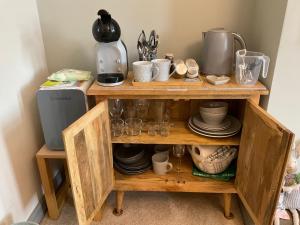 a wooden shelf with cups and dishes on it at No.3 in Cardiff