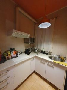 a kitchen with white cabinets and a sink and a light at Russafa Youth Hostel in Valencia +24 photos