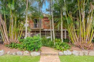 una casa de ladrillo con palmeras delante de ella en Fiesta on Lawson - Belle Escapes Byron Bay, en Byron Bay