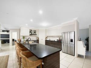 a kitchen with a black counter top and a refrigerator at Family Entertainer with Pool - Luxury Holiday House in Lennox Head in Lennox Head
