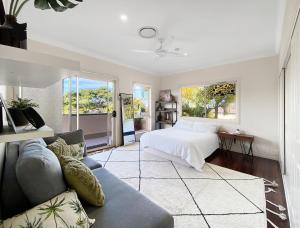 a bedroom with a bed and a couch at Family Entertainer with Pool - Luxury Holiday House in Lennox Head in Lennox Head +14 photos