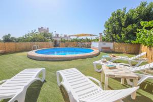 ein Hof mit weißen Stühlen und einem Swimmingpool in der Unterkunft Casa Rural Los Miradores in Marchena