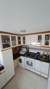 a small kitchen with a sink and a washing machine at El apartamento de arriba in Cedeira