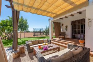 a patio with couches and a table on a deck at Casa Rural La Teja in Marchena