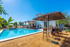 a swimming pool in front of a villa at Casa Rural La Teja in Marchena