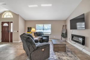 a living room with two chairs and a tv at Micanopy Lake Retreat home in Micanopy
