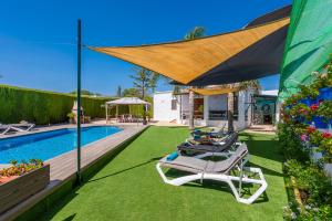 a group of lawn chairs sitting next to a swimming pool at Casa Rural Casita de la Cantera in La Lantejuela