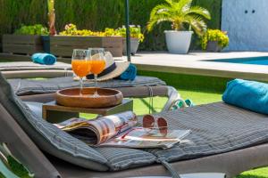 a table with two glasses of orange juice and a magazine at Casa Rural Casita de la Cantera in La Lantejuela