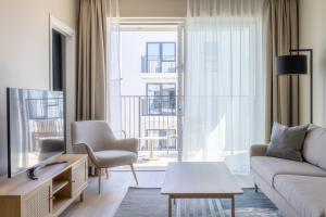 a living room with a couch and a tv at Stay North Paradis in Stavanger