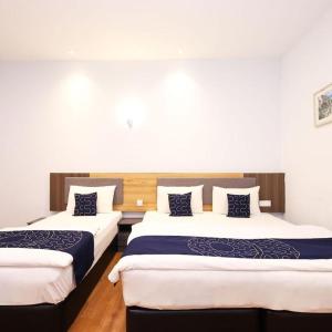 two beds in a room with white walls at Agape Hotel Selayang in Batu Caves +23 photos