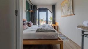a bedroom with a bed in a room with a window at WOT Ericeira Surf Hostel in Ericeira