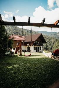a house with a swing in front of it at Casa de vacanta Aida in Zărneşti
