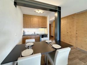a dining room with a table and white chairs at Valdor Residence- Crans Montana- Swiss Alps in Crans-Montana