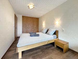 a bedroom with a bed with white sheets and blue pillows at Valdor Residence- Crans Montana- Swiss Alps in Crans-Montana +10 photos