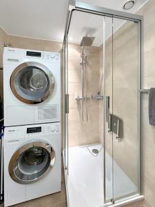 a washer and dryer in a bathroom with a shower at Valdor Residence- Crans Montana- Swiss Alps in Crans-Montana