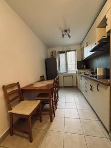 cocina con mesa, sillas, mesa y barra en Central Elegance Apartment, en Timisoara
