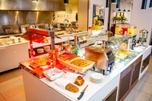 a buffet line in a restaurant with a lot of food at Hilton Garden Inn Nairobi Airport in Nairobi