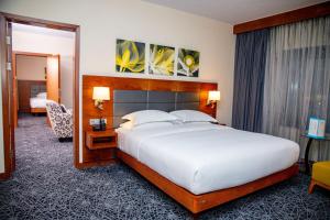 a bedroom with a large white bed and a mirror at Hilton Garden Inn Nairobi Airport in Nairobi